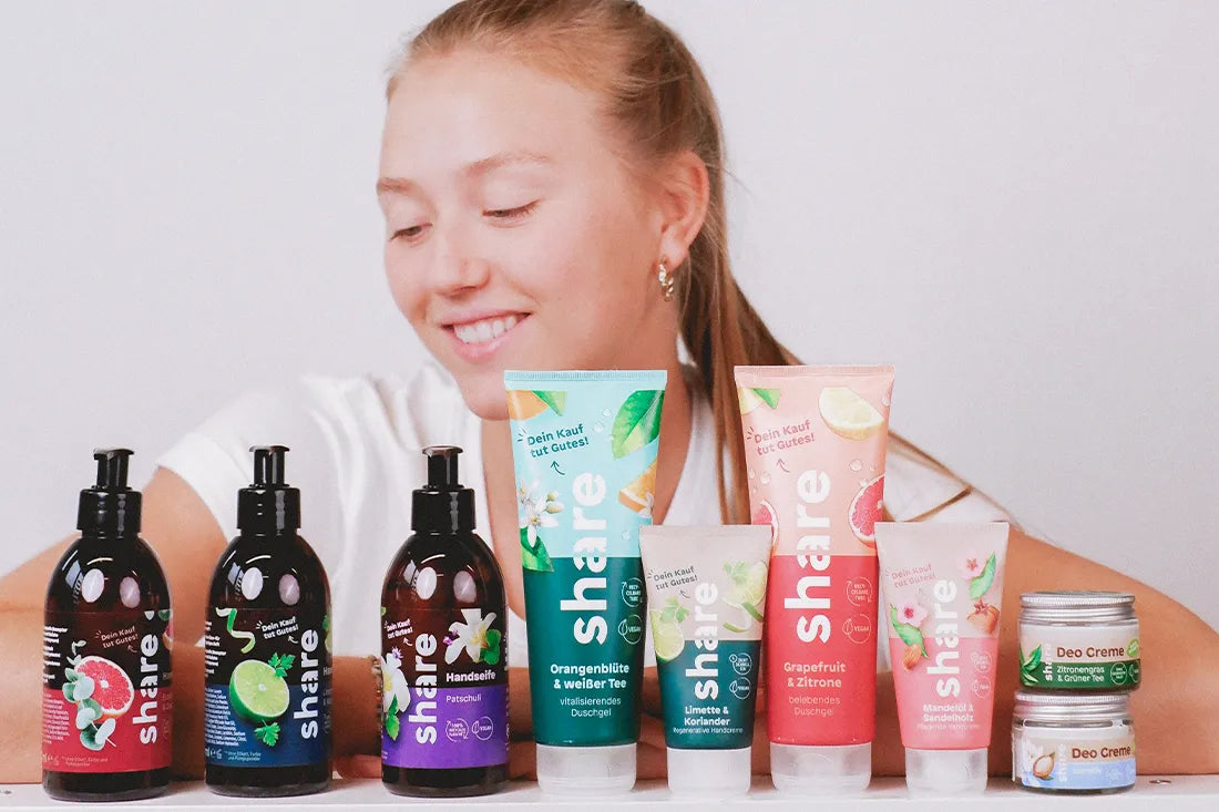 Model sitzt vor Pflegeprodukten von share, vegane Seife, vegan Bodylotion und Handcreme