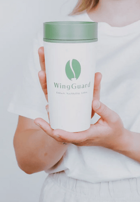 Nachhaltiger Kaffeebecher - in der Farbe creme mit grünem Deckel